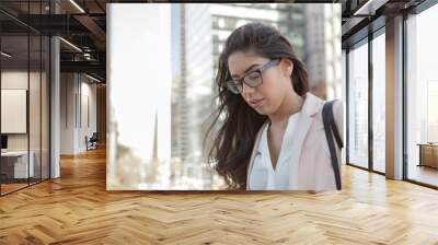 young latin professional woman with glasses in the city Wall mural