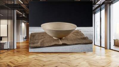 wooden bowl on a jute cloth placed on a rustic white wooden table with dark gray background Wall mural