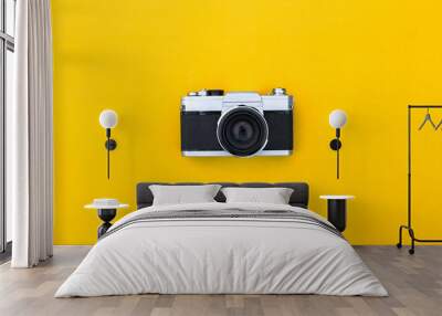 Flat lay black vintage camera and film on yellow paper background Wall mural