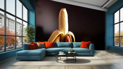 Pealed banana in human hand Wall mural