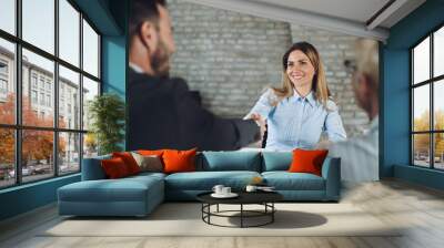 Business team congratulating their happy candidate on successful job interview in the office Wall mural