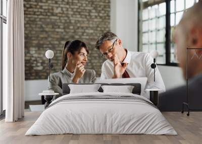 Businessman whispering to his colleague during a job interview in the office Wall mural