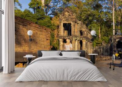 Female tourist in the ruins of Preah Khan temple in Angkor complex, overgrown by trees, Cambodia Wall mural