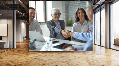 Happy businesswoman shaking hands on a meeting in the office.  Wall mural