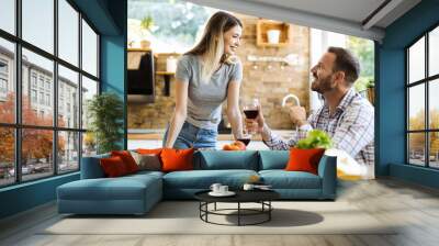 Happy young couple talking during lunch time at dining table Wall mural