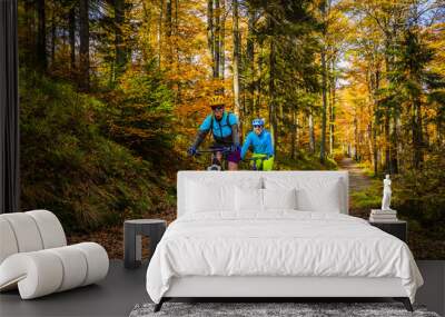 cycling, mountain biker couple on cycle trail in autumn forest. mountain biking in autumn landscape  Wall mural