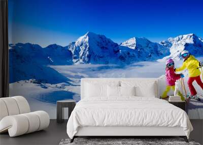 Happy family enjoying winter vacations in mountains. Playing with snow, Sun in high mountains. Winter holidays. Wall mural