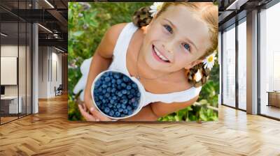 Lovely girl with fresh blueberries in the garden Wall mural