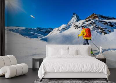 Man backcountry skiing on powder snow with Matterhorn in background, Zermatt in Swiss Alps. Wall mural