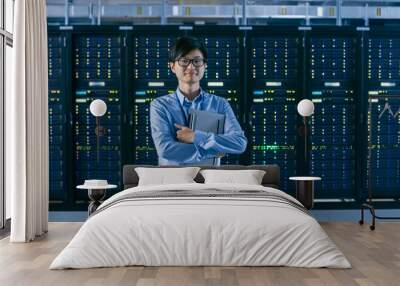  In the Modern Data Center: Portrait of IT Engineer Standing with Server Racks Behind Him, Holding Laptop after Finishing Doing Maintenance and Diagnostics Procedure. Wall mural