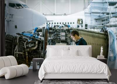 Aircraft Maintenance Mechanic Inspecting and using Tablet Airplane Jet Engine in Hangar Wall mural