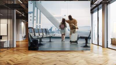 Airport Terminal: Beautiful Mother and Cute Little Daughter Wait for their Vacation Flight, Looking out of Window for Arriving and Departing Airplanes. Young Family in Boarding Lounge of Airline Hub Wall mural