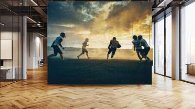 American Football Field Two Teams Compete: Players Pass and Run Attacking to Score Touchdown Points. Professional Athletes Fight for the Ball, Tackle. Dramatic Golden Hour Sunset Wall mural