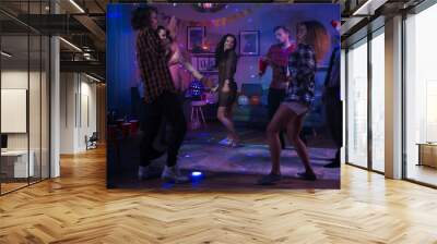 At the College House Party: Diverse Group of Friends Have Fun, Dancing and Socializing. Boys and Girls Dance in the Circle. Disco Neon Strobe Lights Illuminating Room.  Wall mural