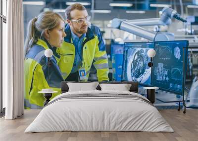 at the factory: male mechanical engineer and female chief engineer work together on the personal com Wall mural