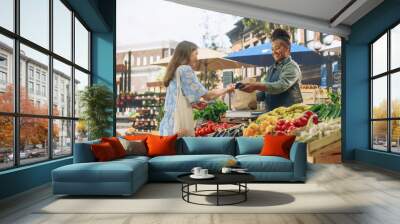 Beautiful Female Customer Buying Sustainable Organic Vegetables From a Joyful Black Female Farmer on a Sunny Summer Day. Successful Street Vendor Managing a Farm Stall at an Outdoors Eco Market Wall mural