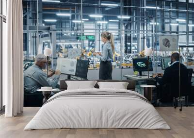 Car Factory Office: Team of Automotive Engineers Working, Using Computers to Design Advanced 3D Models for High-Tech Engines. Automated Robot Arm Industrial Assembly Line Manufacturing Vehicles Wall mural