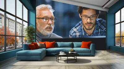 Chief Creative Designer Shows Desktop Computer Screen to a Young Developer, They Discuss Project. Two Professionals Having Discussion. Choosing Right Design Concept. Evening in the Studio Office Wall mural