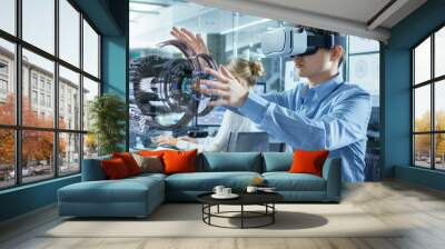 Computer Science Engineer wearing Virtual Reality Headset Works with 3D Model Hologram Visualization, Makes Gestures. In the Background Engineering Bureau with Busy Coworkers. Wall mural