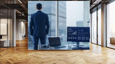 Confident Businessman in a Suit Contemplating Business Deal in His Office, Looking out of the Window. Window Has Panoramic View on Big City Business District. Wall mural