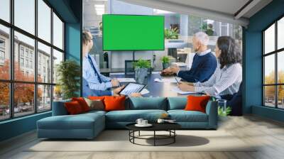 Diverse Group of Successful Business People in the Conference Room with  Green Screen Chroma Key TV on the Wall. They Work on a Company's Growth, Share Charts and Statistics. Wall mural