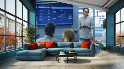 Diverse Modern Office: Successful Black Female Digital Entrepreneur Uses TV Screen with Big Data, Statistics, Talks about Company Growth, Discusses Strategy with Investors, Top Managers, Executives Wall mural