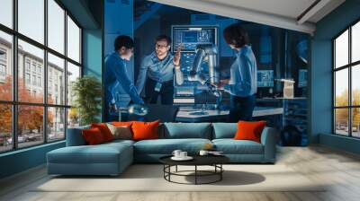 Diverse Team of Engineers with Laptop and a Tablet Analyse and Discuss How a Futuristic Robotic Arm Works and Moves a Metal Object. They are in a High Tech Research Laboratory with Modern Equipment. Wall mural