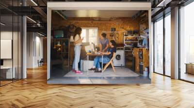 Diverse Team Of Three Young Startup Company Founders Working In Retro Garage, Using Old Desktop Computer. Male And Female Entrepreneurs Developing Innovative Online Service In Nostalgic Nineties. Wall mural