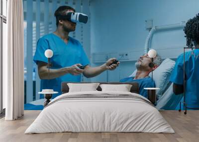 Doctor Wearing Virtual Reality Headset and Holding Joysticks Cures Senior Patient who is Lying in Bed. Most Advanced Technologies Used in Futuristic Hospital Ward. Wall mural