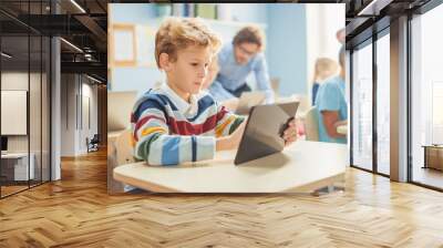 Elementary School Computer Science Class: Smart Boy Uses Digital Tablet Computer, His Classmates work with Laptops too. Children Getting Modern Education in STEM, Playing and Learning Wall mural