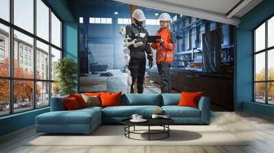 Engineer and Manual Labor Worker in a Bionic Exoskeleton Prototype Check Development Test Results on a Tablet. Heavy Industry Factory Engineers Discuss Warehouse Work and Futuristic Technology.  Wall mural