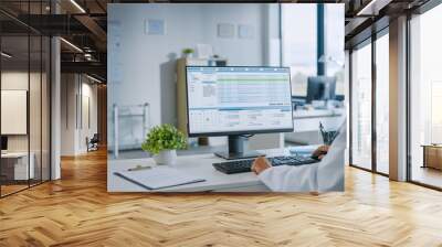 Experienced Female Medical Doctor Wearing White Coat Working on Personal Computer in a Health Clinic. Medical Health Care Professional Working with Test Results, Patient Treatment Planning. Wall mural