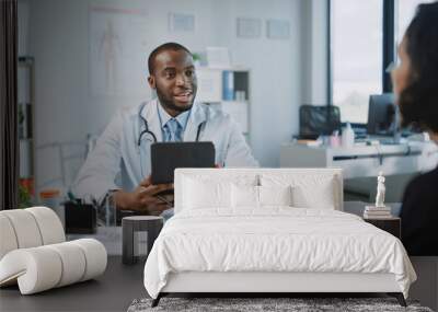 Family Doctor is Delivering Great News About Female Patient's Medical Results During Consultation in a Health Clinic. Physician in White Lab Coat Sitting with a Tablet in Hospital Office.  Wall mural