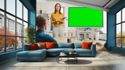 Female Project Manager Holds Meeting Presentation for a Team of Developers. She Shows Green Screen Interactive Whiteboard Device for Business Planning Concept. Young People Work in Creative Office. Wall mural