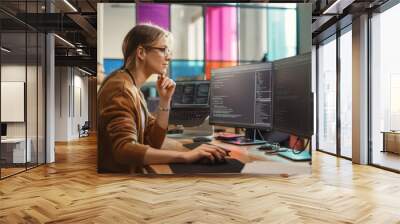 Female Software Engineer Writing Code on Desktop Computer with Multiple Screens Setup in Coworking Office Space. Professional Caucasian Woman Working on SaaS Platform For Innovative Startup. Wall mural