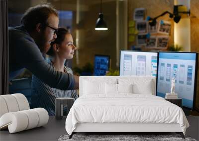 Female UX Architect Has Discussion with Male Design Engineer, They Work on Mobile Application Late at Night, She Drinks Coffee. In the Background Wall with Project Sticky Notes. Wall mural