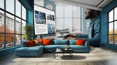 Handsome Black African American Specialist Working on Desktop Computer in Creative Home Living Room. Freelance Male is Reading News for Financial Market Analysis and Report for Clients and Employer. Wall mural