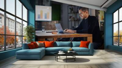 Handsome Caucasian Male is Working on Laptop Computer while Sitting Behind a Conference Table in Meeting Room in an Creative Agency. Project Manager is Busy With Business Strategy and Development. Wall mural