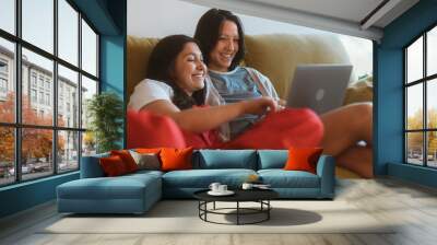 Happy Lesbian Couple Resting on the Sofa Use Laptop. Sunny Morning Two Girlfriends in Love have Fun Talking, Watching Videos, Doing e-shopping. Young Partners Share Tender Moments Wall mural