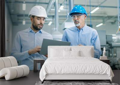 Head of the Project Holds Laptop and  Discusses Product Details with Chief Engineer while They Walk Through Modern Factory. Wall mural