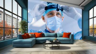 In the Hospital Operating Room Professional Surgeon Puts on Surgical Flashlight, Before Surgery Operation. Wall mural