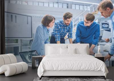 In the Industrial Engineering Facility: Diverse Group of Engineers and Technicians on a Meeting Gather Around Table with Engine Design Technical Drafts, Have Discussion, Analyse Technology Wall mural