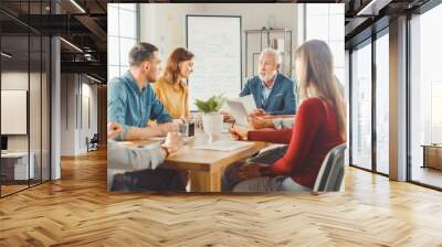 In the Meeting Room Team of Businesspeople, Entrepreneurs and Specialists sitting at the Conference Table Have Discussions, Solve Problems, Use Tablet, Laptop, Share Documents with Statistics, Charts Wall mural