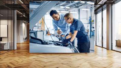 Instructor with a Tablet Computer is Giving a Task for a Future Mechanic. Female Student Inspects the Car Engine. Assistant is Checking the Cause of a Breakdown in the Vehicle in a Car Service.  Wall mural