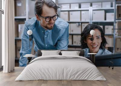 Male and Female Warehouse Inventory Managers Talking, Solving Problems, Using Personal Computer and Checking Stock. In the Background Rows of Shelves Full of Cardboard Box Packages. Wall mural