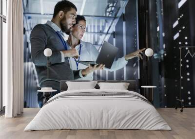 male it specialist holds laptop and discusses work with female server technician. they're standing i Wall mural