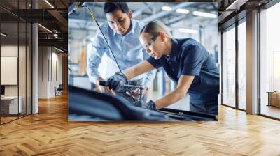 Manager Checks Diagnostics Results on a Tablet Computer and Explains an Engine Breakdown to an Female Mechanic. Car Service Employee Uses a Ratchet to Fix the Engine Component. Modern Clean Workshop. Wall mural