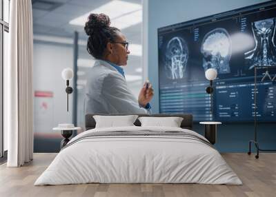 Medical Science Hospital: Confident Black Female Neurologist, Neuroscientist, Neurosurgeon, Looks at TV Screen with MRI Scan with Brain Images, Thinks about Sick Patient Treatment Method. Saving Lives Wall mural