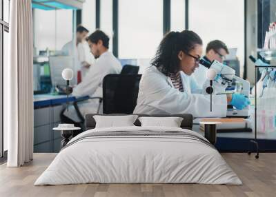 Medical Science Laboratory: Beautiful Black Scientist Looking Under Microscope Does Analysis of Test Sample. Diverse Team of Young Specialists, Using Advanced Technology Equipment. Wall mural