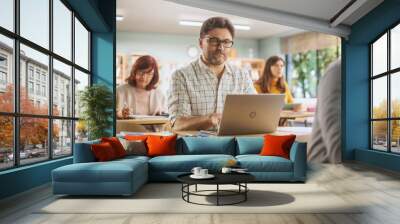 Middle-Aged Man Studying in Classroom, Using Laptop to Write Down Lecture Notes. Group of People Taking a Workshop on Improving Professional Soft Skills. Adult Education Center Concept Wall mural